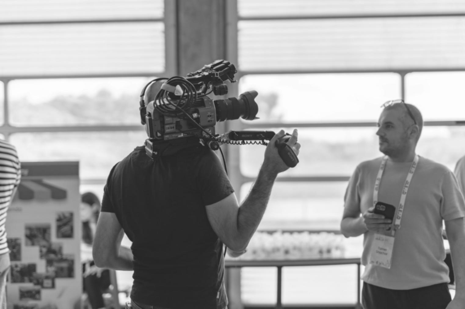 Professional video editing workspace showing multiple monitors and editing timeline